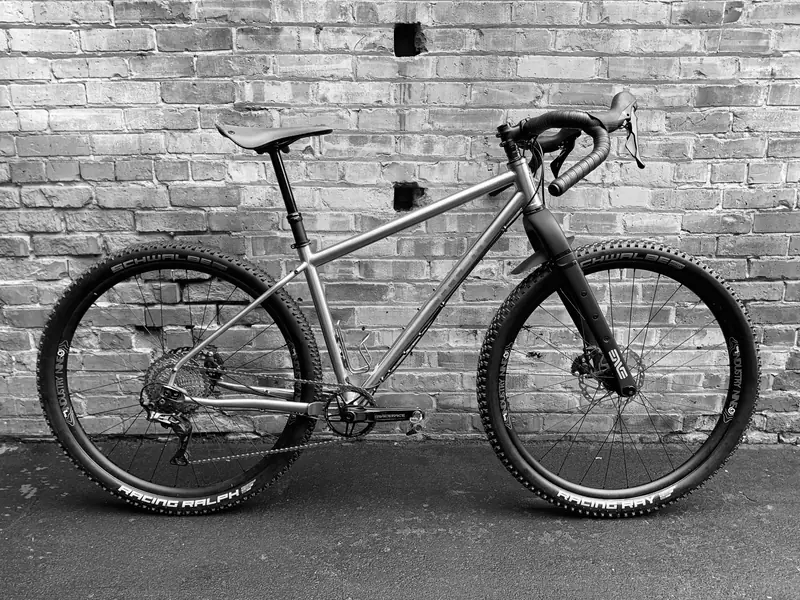 Drop-bar gravel bike against a brick wall