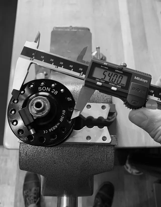 Digital calipers measuring a SON 28 dynamo hub at 54.00 mm