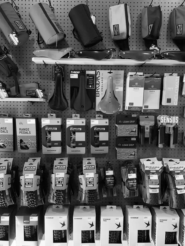 Bags, saddles, grips and tires displayed on the shop's pegboard wall